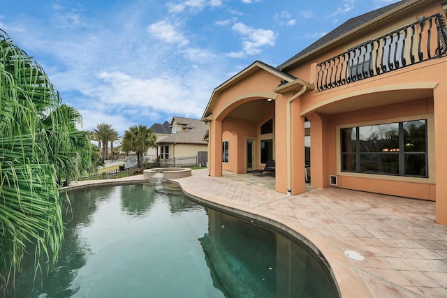 view of swimming pool with a patio area, fence, and a pool with connected hot tub