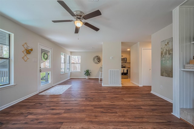 interior space featuring baseboards, a ceiling fan, and dark wood-style flooring