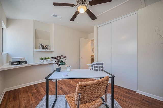 office area featuring a ceiling fan, wood finished floors, visible vents, and baseboards