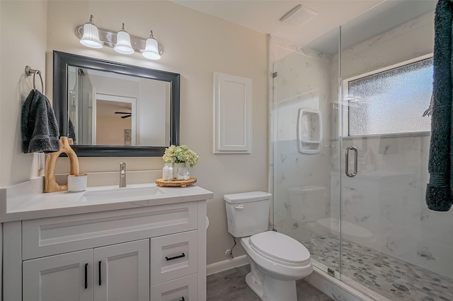 bathroom featuring a marble finish shower, visible vents, toilet, and vanity