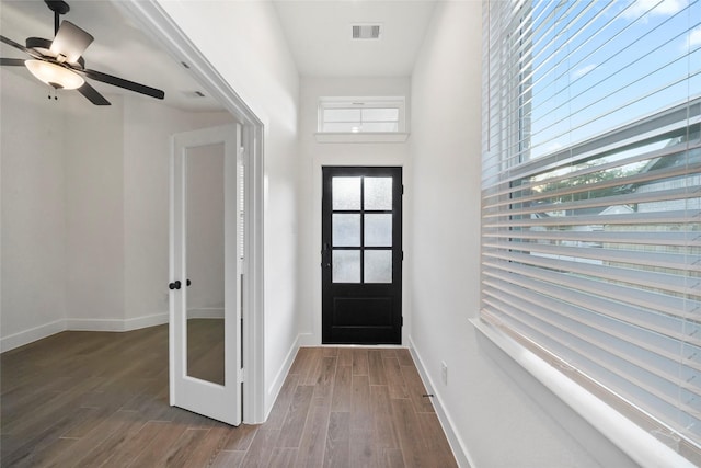 entrance foyer with a ceiling fan, wood finished floors, visible vents, and baseboards