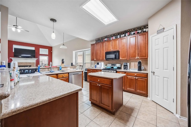 kitchen featuring a sink, a kitchen island, appliances with stainless steel finishes, brown cabinetry, and pendant lighting