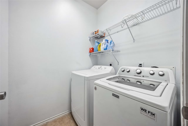 laundry area with laundry area, light tile patterned floors, baseboards, and independent washer and dryer