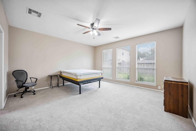 game room with a ceiling fan, visible vents, and light carpet