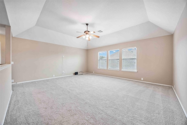 unfurnished room with carpet, visible vents, vaulted ceiling, and a ceiling fan