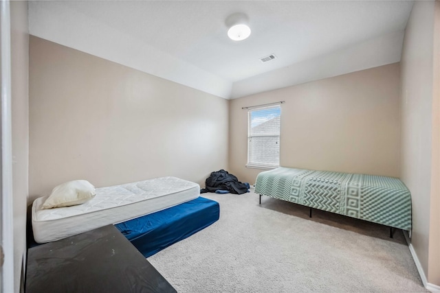 carpeted bedroom with visible vents and baseboards