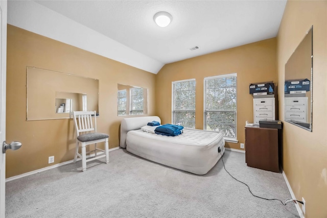 bedroom with lofted ceiling, multiple windows, carpet, and visible vents