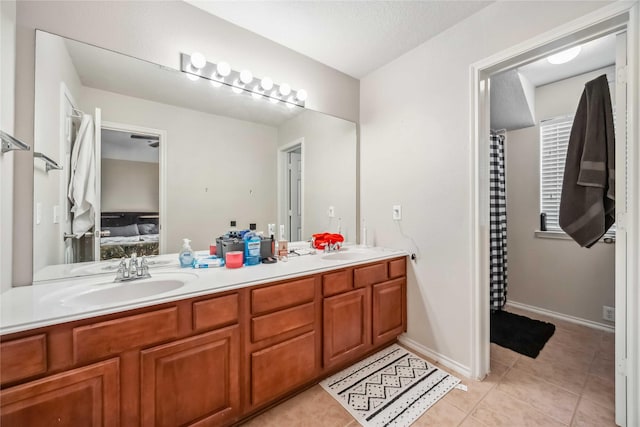 ensuite bathroom with tile patterned flooring, double vanity, a sink, and ensuite bathroom