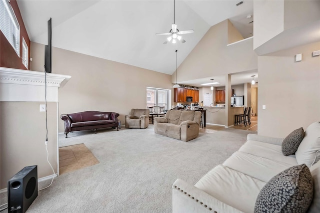 living room featuring high vaulted ceiling, a ceiling fan, and light colored carpet