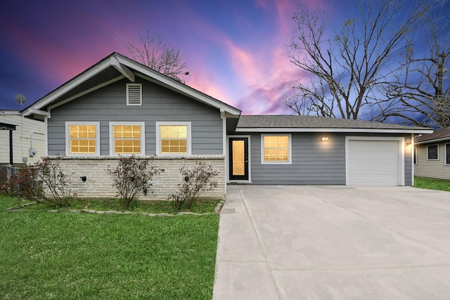 ranch-style home featuring an attached garage, concrete driveway, brick siding, and a front yard