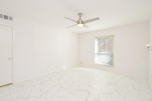 empty room with visible vents, marble finish floor, a ceiling fan, and baseboards