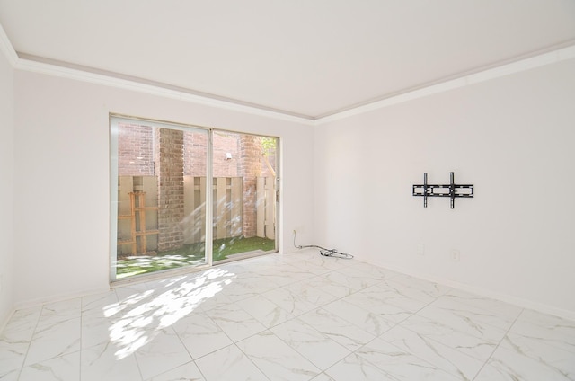 spare room featuring ornamental molding, marble finish floor, and baseboards