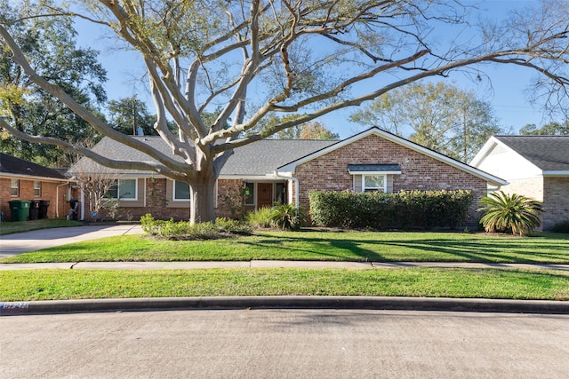 ranch-style home featuring a front lawn and brick siding