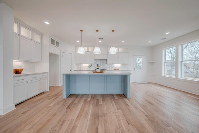 kitchen featuring light countertops, hanging light fixtures, and white cabinetry