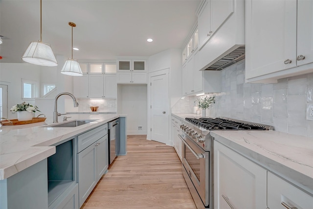 kitchen with stainless steel appliances, white cabinetry, glass insert cabinets, and decorative light fixtures