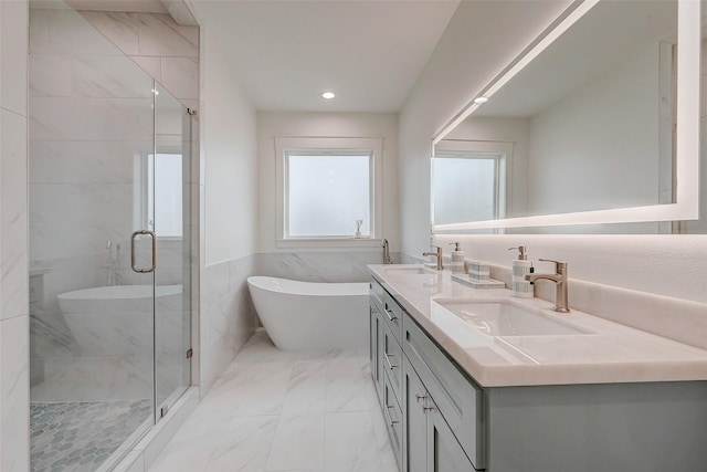 full bathroom with marble finish floor, double vanity, a stall shower, and a sink