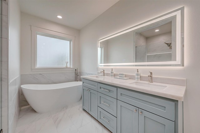 bathroom with a soaking tub, marble finish floor, a sink, and a shower stall