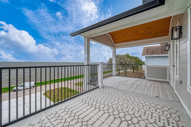 view of patio / terrace featuring a water view and a balcony