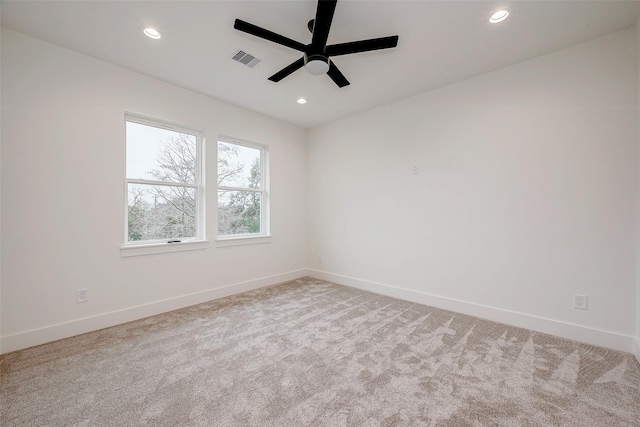 empty room featuring light colored carpet, visible vents, baseboards, and recessed lighting