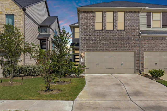 view of front of property with driveway, an attached garage, and brick siding