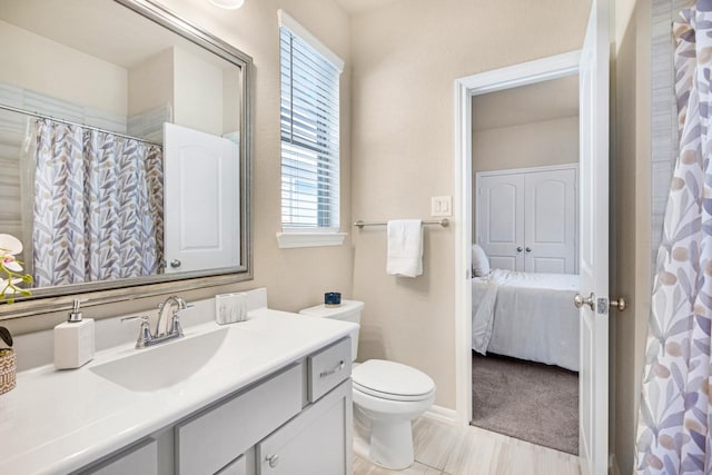 bathroom featuring a shower with shower curtain, toilet, vanity, and ensuite bath