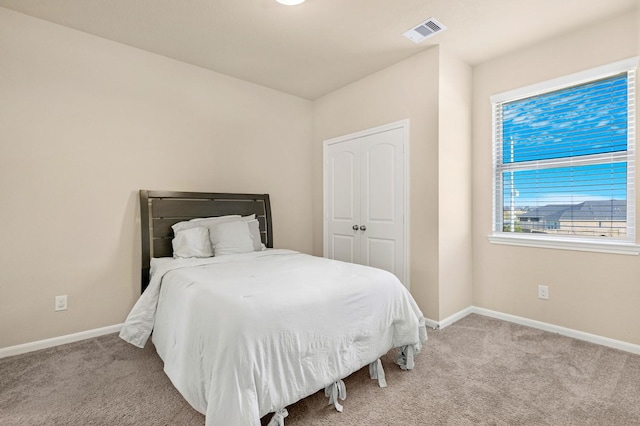 bedroom with light carpet, visible vents, and baseboards