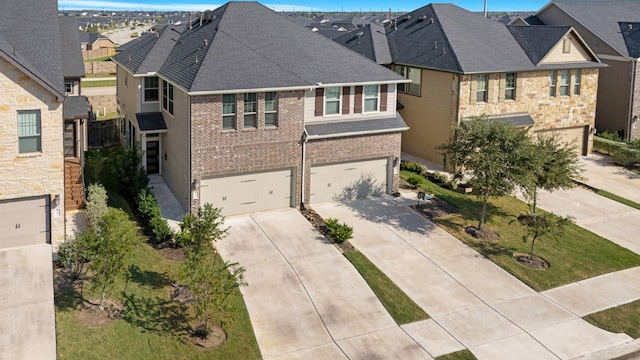 view of front of home with a garage, driveway, a residential view, and brick siding