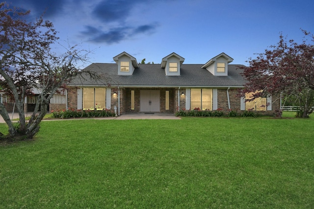 cape cod house with a front lawn