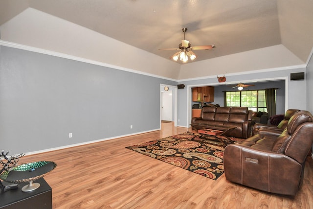 living area with light wood finished floors, a raised ceiling, and baseboards