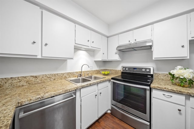 kitchen with white cabinets, appliances with stainless steel finishes, light countertops, under cabinet range hood, and a sink