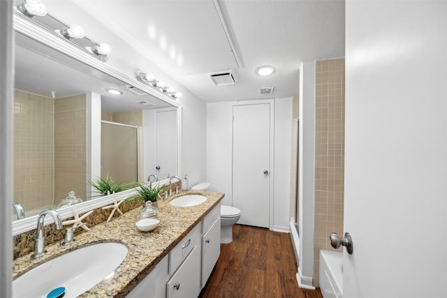 bathroom with a stall shower, visible vents, a sink, and toilet