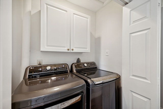 washroom with cabinet space and washer and dryer