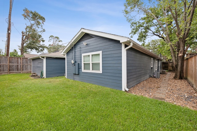 rear view of house with central AC, a lawn, and a fenced backyard