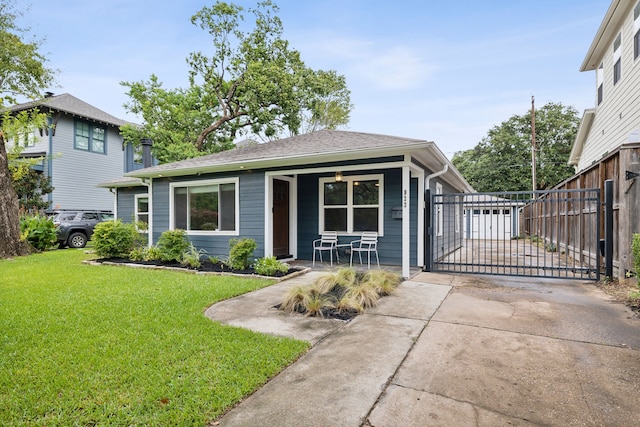 view of front facade with a shingled roof, fence, a porch, and a front yard