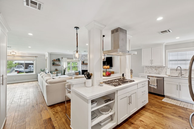 kitchen with a sink, appliances with stainless steel finishes, island exhaust hood, and visible vents