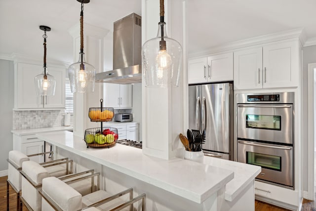 kitchen featuring island range hood, white cabinetry, a kitchen breakfast bar, appliances with stainless steel finishes, and backsplash