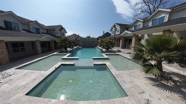 view of pool with a pool with connected hot tub and a residential view