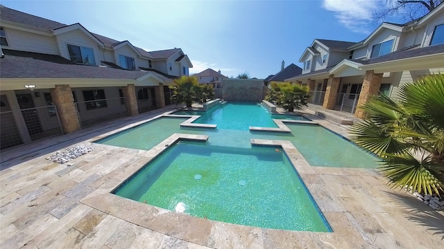 view of swimming pool featuring a residential view and a pool with connected hot tub