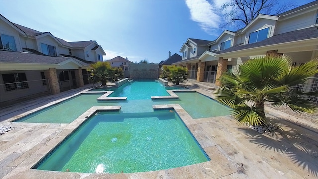 view of pool with a pool with connected hot tub and a residential view