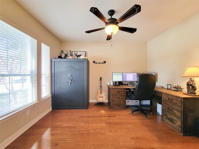 office area with baseboards, a ceiling fan, and light wood-style floors