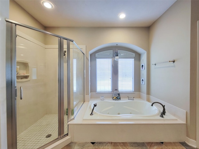 full bathroom with recessed lighting, a jetted tub, and a shower stall