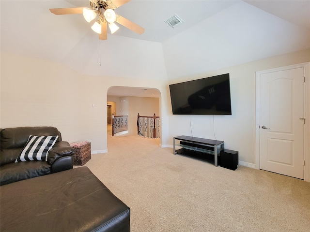 living area with light carpet, baseboards, visible vents, and arched walkways