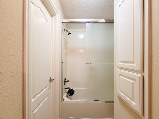 full bath featuring a textured wall, a textured ceiling, and shower / tub combination