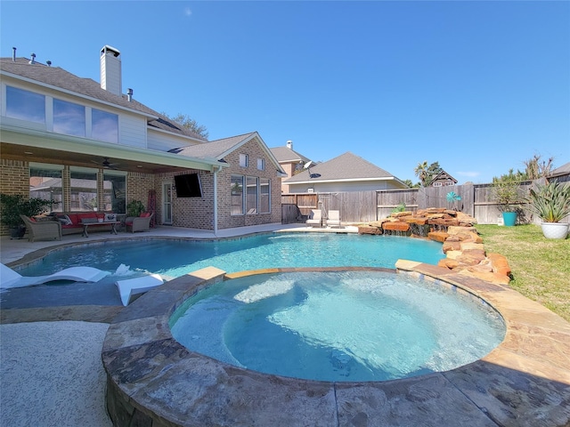 view of swimming pool featuring a pool with connected hot tub, a fenced backyard, ceiling fan, and an outdoor living space