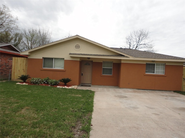 ranch-style home featuring concrete driveway, a front lawn, and stucco siding