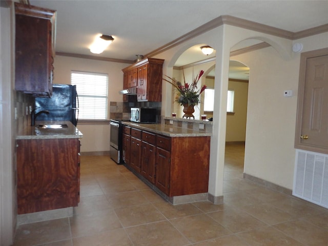 kitchen featuring arched walkways, stainless steel appliances, visible vents, tasteful backsplash, and crown molding