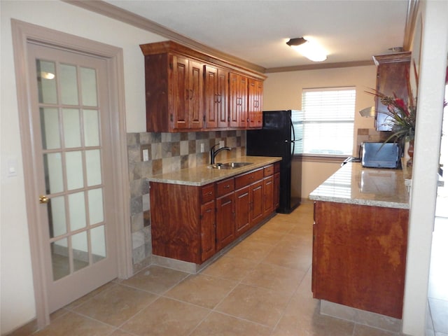 kitchen featuring crown molding, a sink, backsplash, and light tile patterned floors