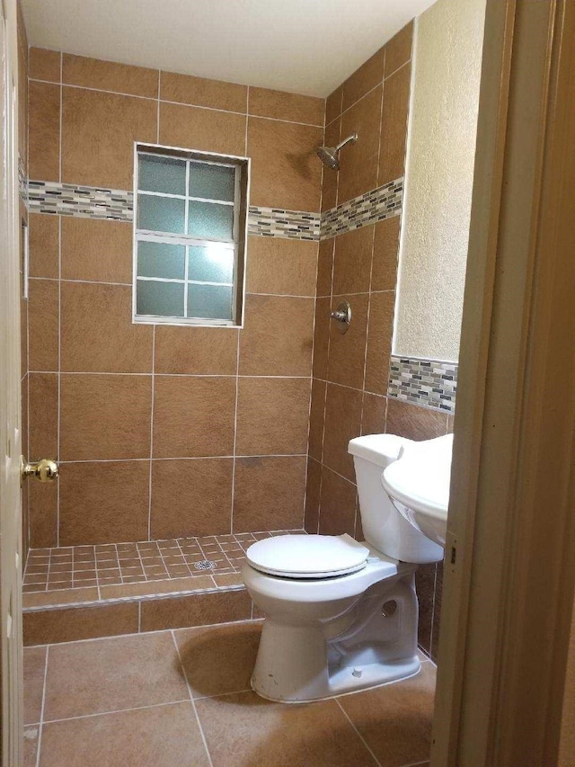 full bath with a stall shower, tile walls, and toilet