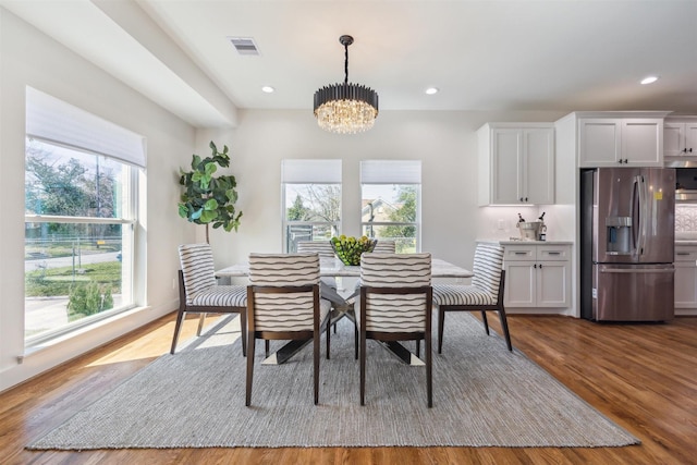 dining room with recessed lighting, visible vents, an inviting chandelier, and wood finished floors