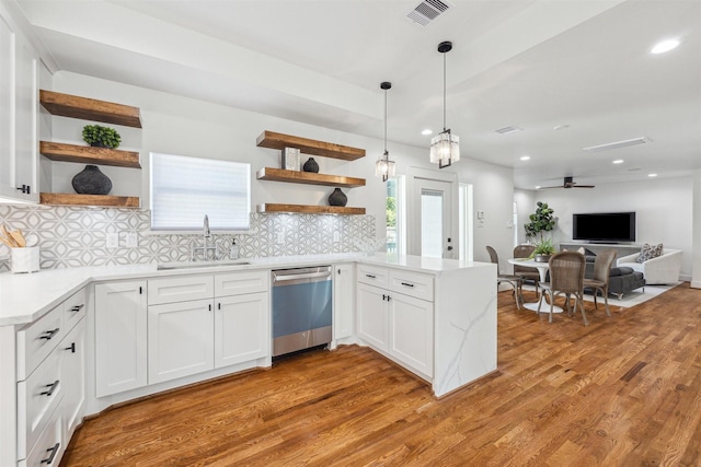 kitchen featuring visible vents, open shelves, a peninsula, a sink, and dishwasher